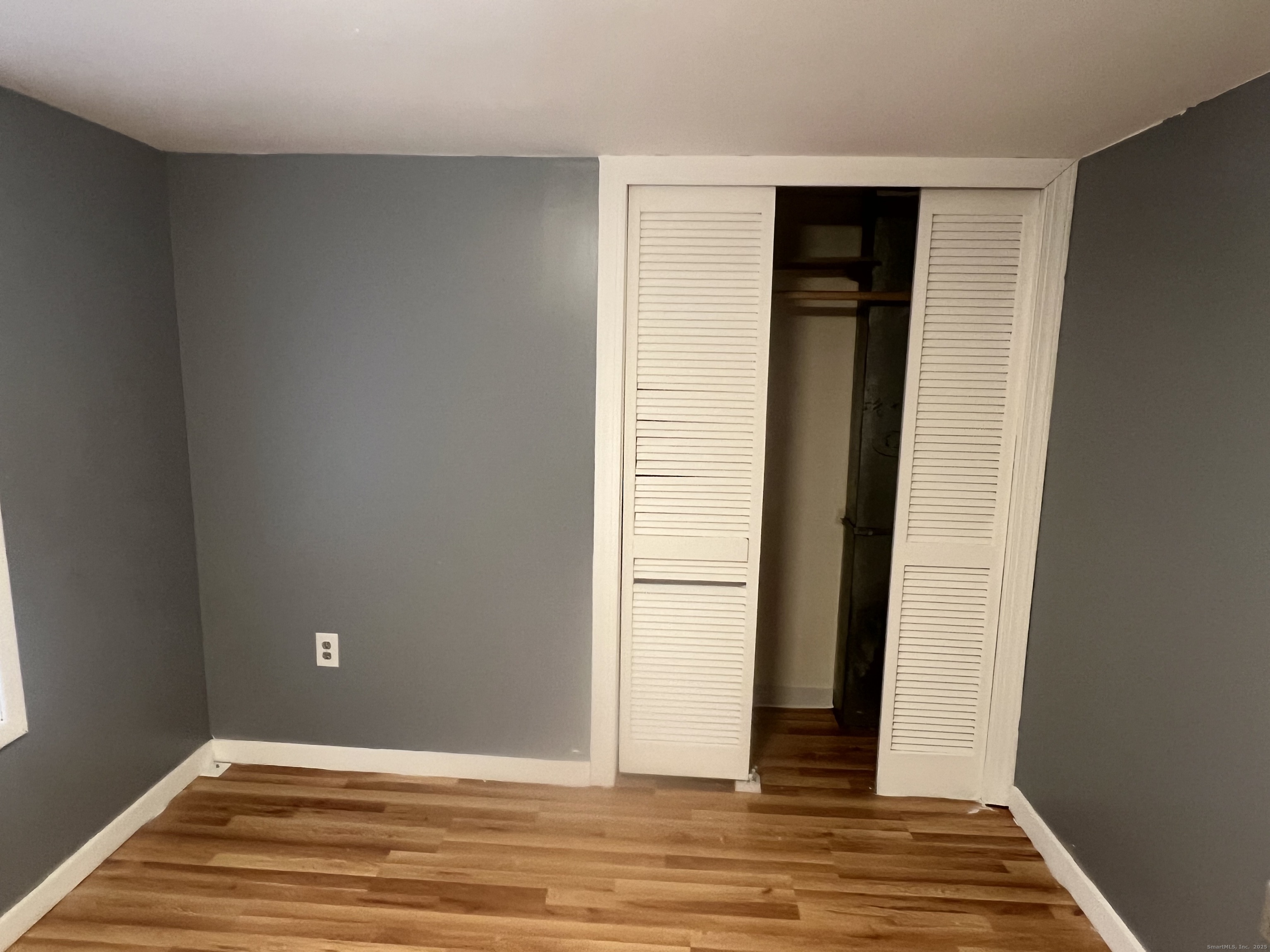 83 Litchfield Street Thomaston, CT 06787 - Photo 19 of 24 an empty room with wooden floor and windows