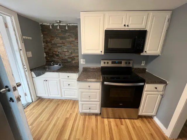 a kitchen with white cabinets and a stove