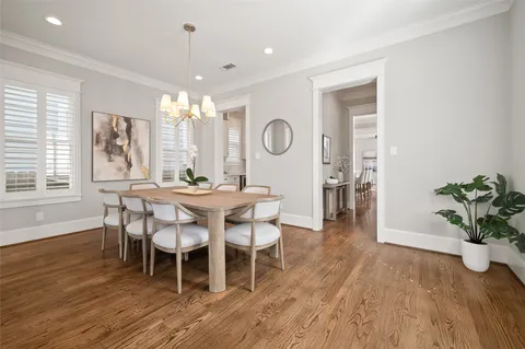 a dining room with furniture potted plants and wooden floor