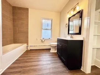 a bathroom with a double vanity sink a large mirror and a bathtub
