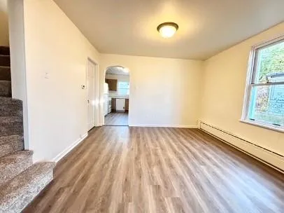 a view of empty room with wooden floor