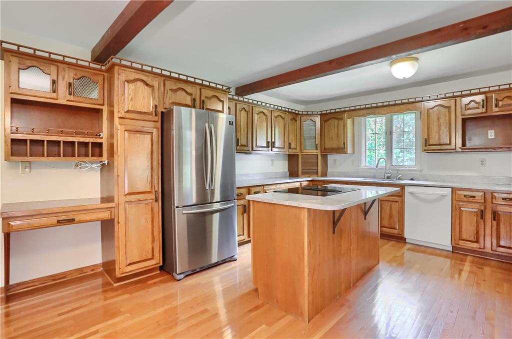 9650 Goehring Road Cranberry Township, PA 16066 - Photo 11 of 47 a kitchen with stainless steel appliances granite countertop a refrigerator a sink dishwasher a stove and a dining table with wooden floor