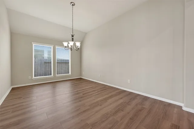 a view of a room with wooden floor and chandelier