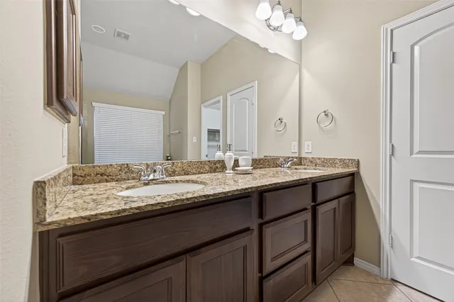 a bathroom with a granite countertop sink a large mirror and a
