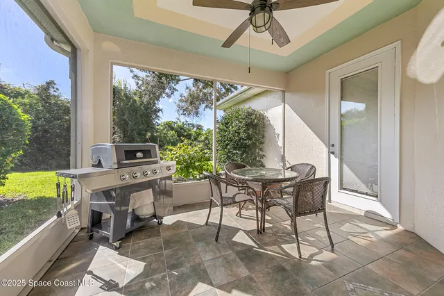 a dining room with furniture and a floor to ceiling window