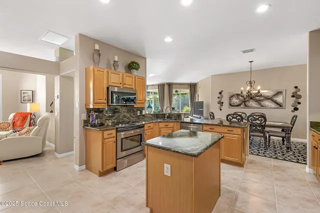 a kitchen with granite countertop a sink stove and refrigerator