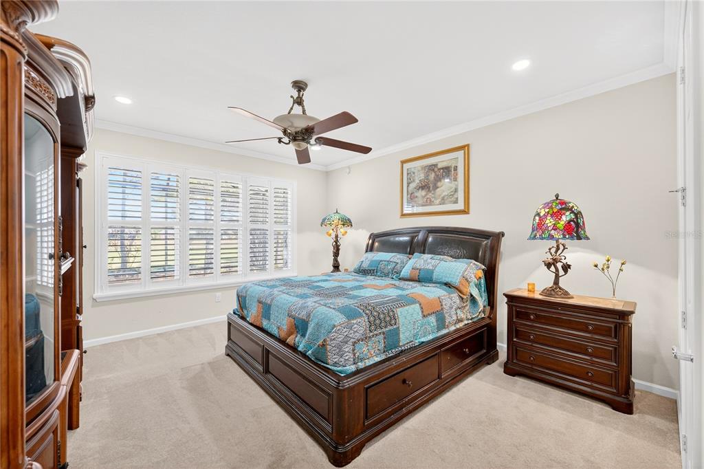 7527 Southwest 97th Terrace Road Ocala, FL 34481 - Photo 42 of 85 a spacious bedroom with a bed and a chandelier