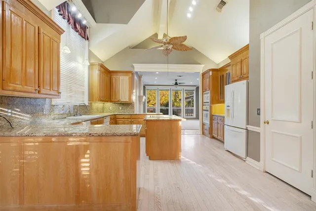 a large kitchen with a lot of counter space and wooden floor