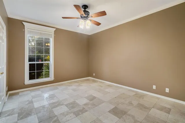 an empty room with windows and fan