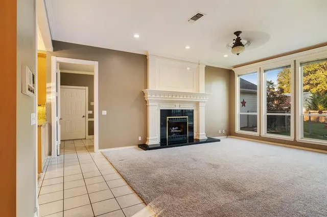a view of an empty room with a fireplace and a window