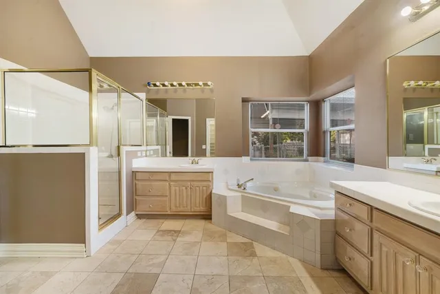 a bathroom with a granite countertop sink a mirror and a bathtub