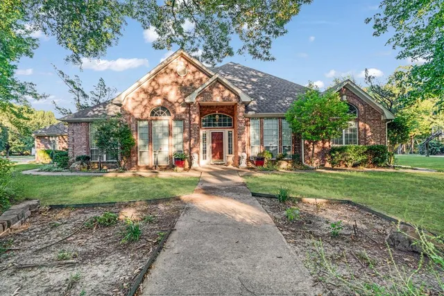 a view of a house with a big yard plants and large trees