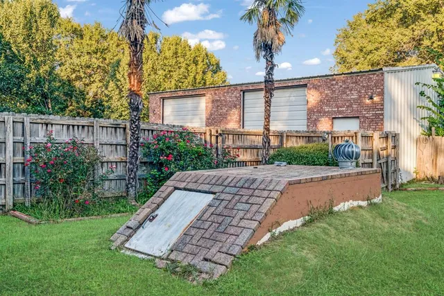 a view of a house with a small yard and wooden fence