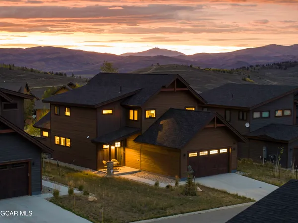 a view of a building with a yard and a mountain view