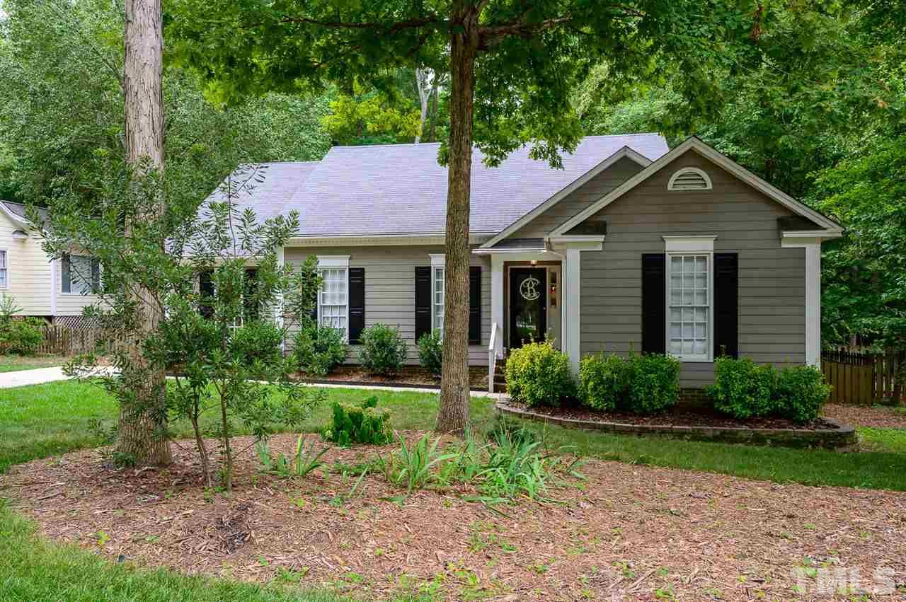 a front view of a house with yard and green space