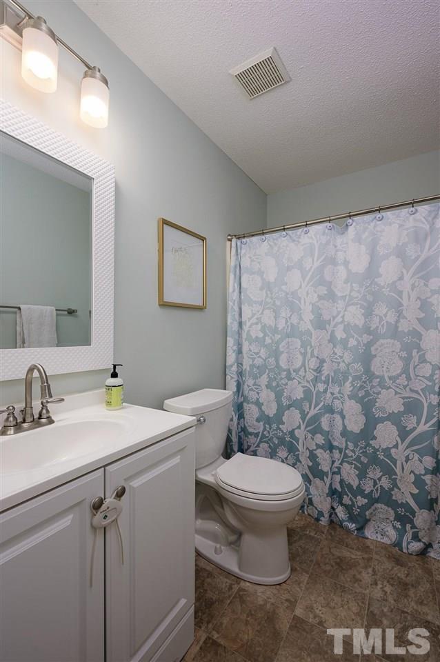 11917 North Exeter Way Raleigh, NC 27613 - Photo 14 of 18 a bathroom with a sink a toilet and a mirror