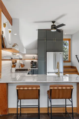 a kitchen with stainless steel appliances kitchen island granite countertop a table chairs in it and wooden floors