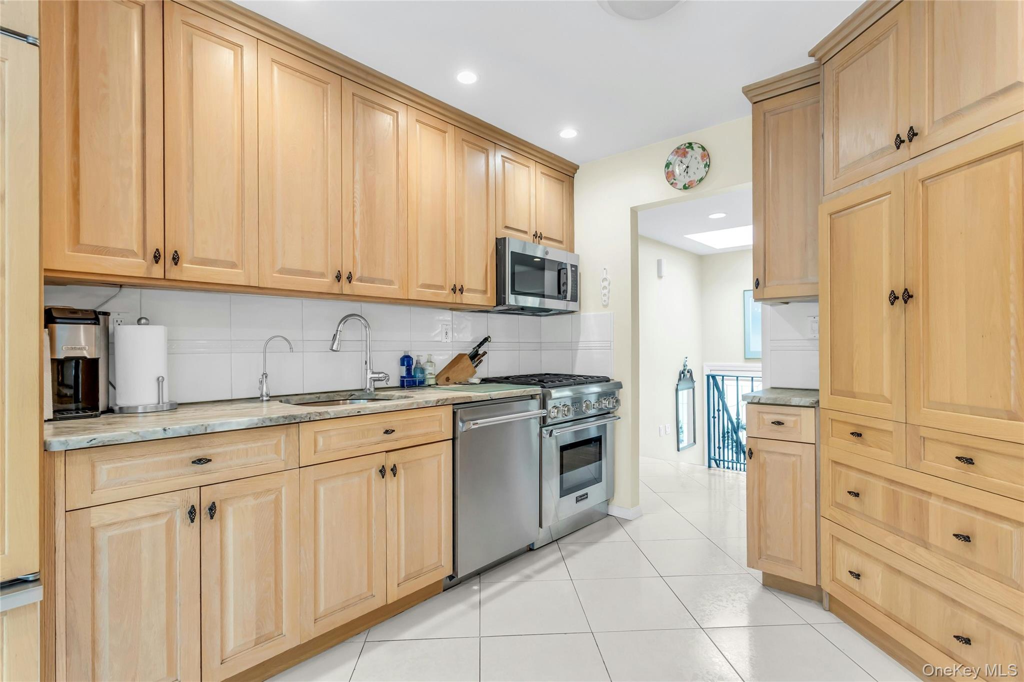 28 Penguin Lane Commack, NY 11725 - Photo 16 of 38 a kitchen with white cabinets and stainless steel appliances
