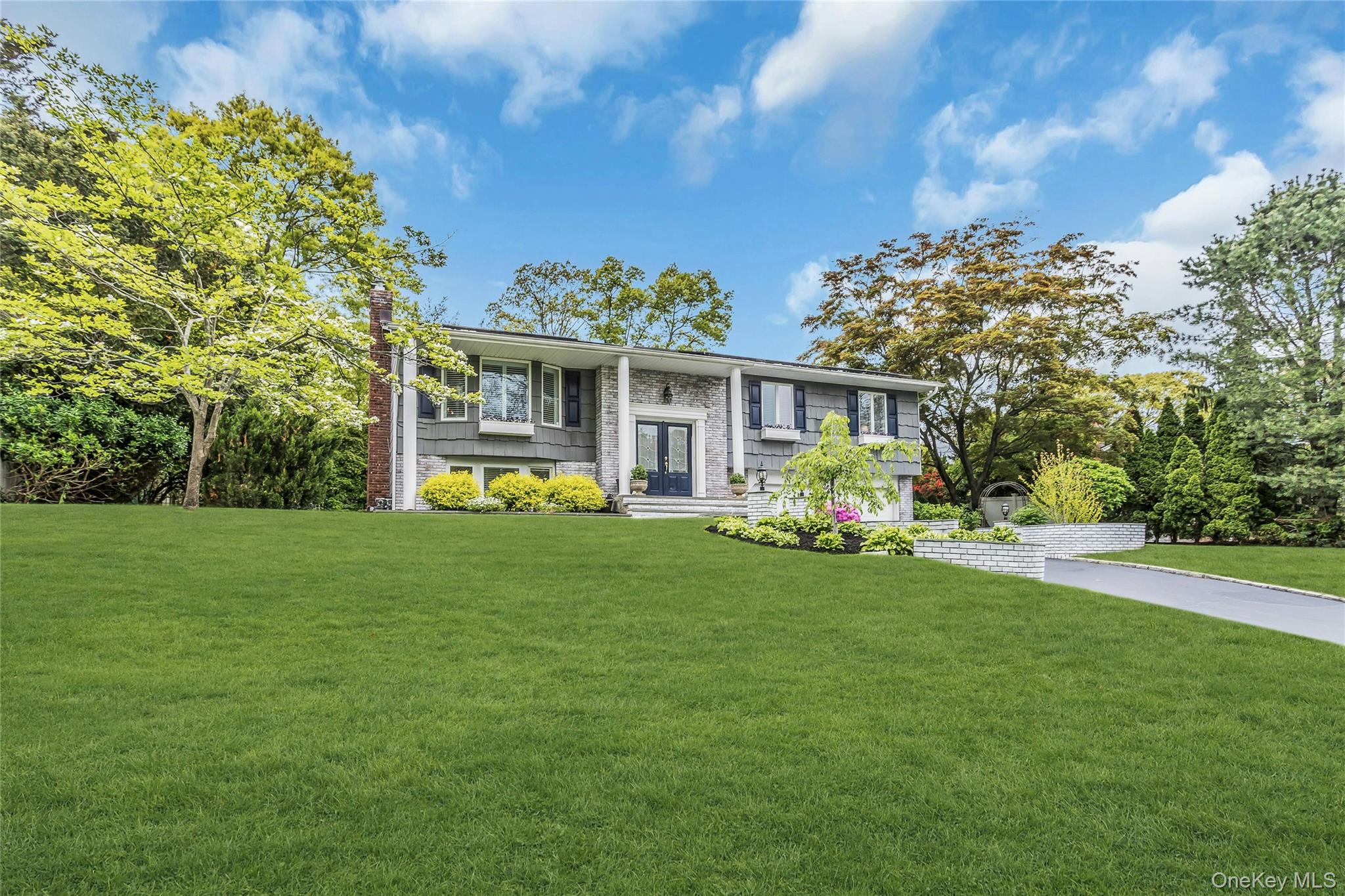 28 Penguin Lane Commack, NY 11725 - Photo 2 of 38 a front view of a house with a garden