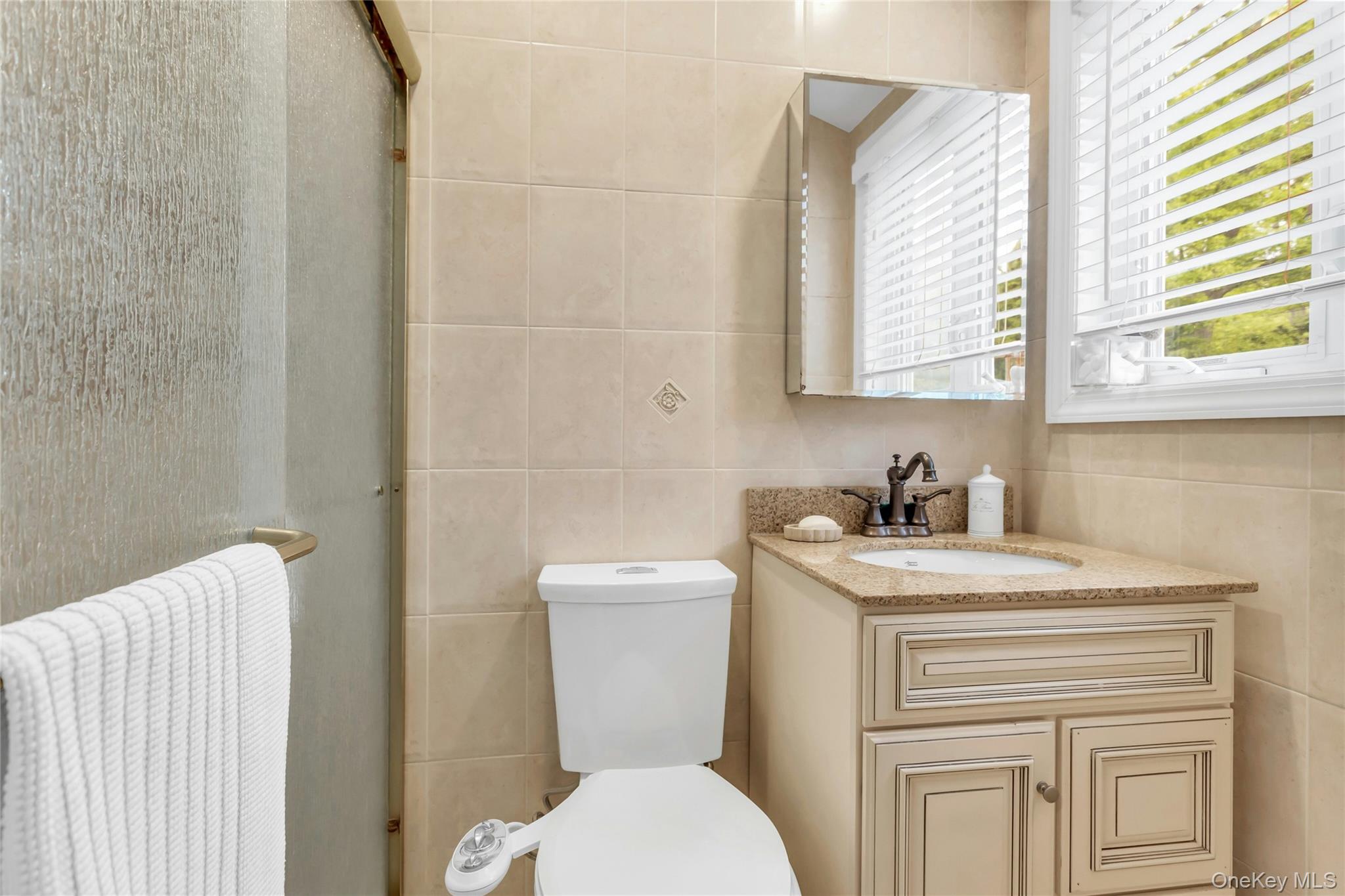 28 Penguin Lane Commack, NY 11725 - Photo 22 of 38 a bathroom with a granite countertop toilet sink and mirror