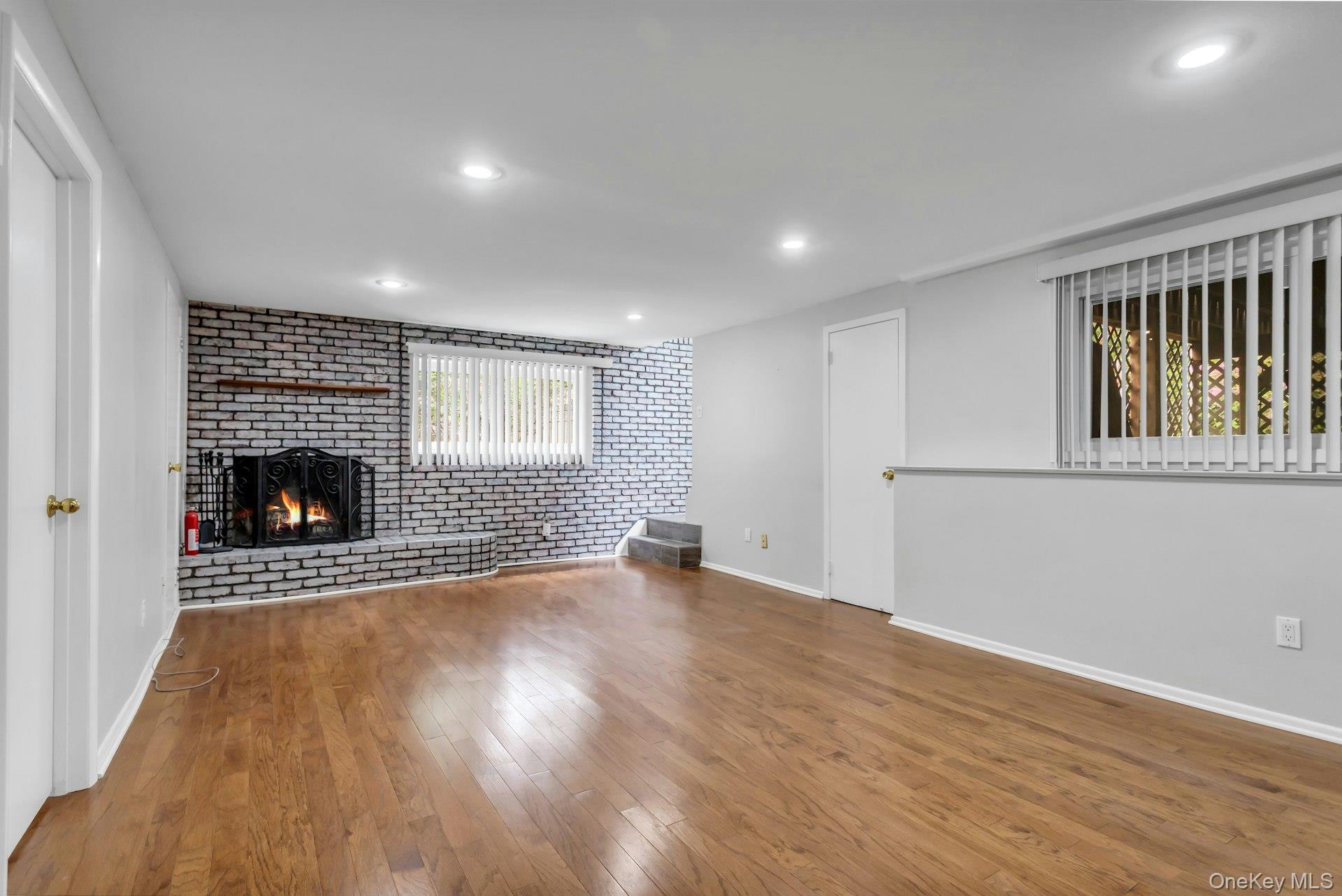 28 Penguin Lane Commack, NY 11725 - Photo 27 of 38 a view of empty room with wooden floor and fireplace