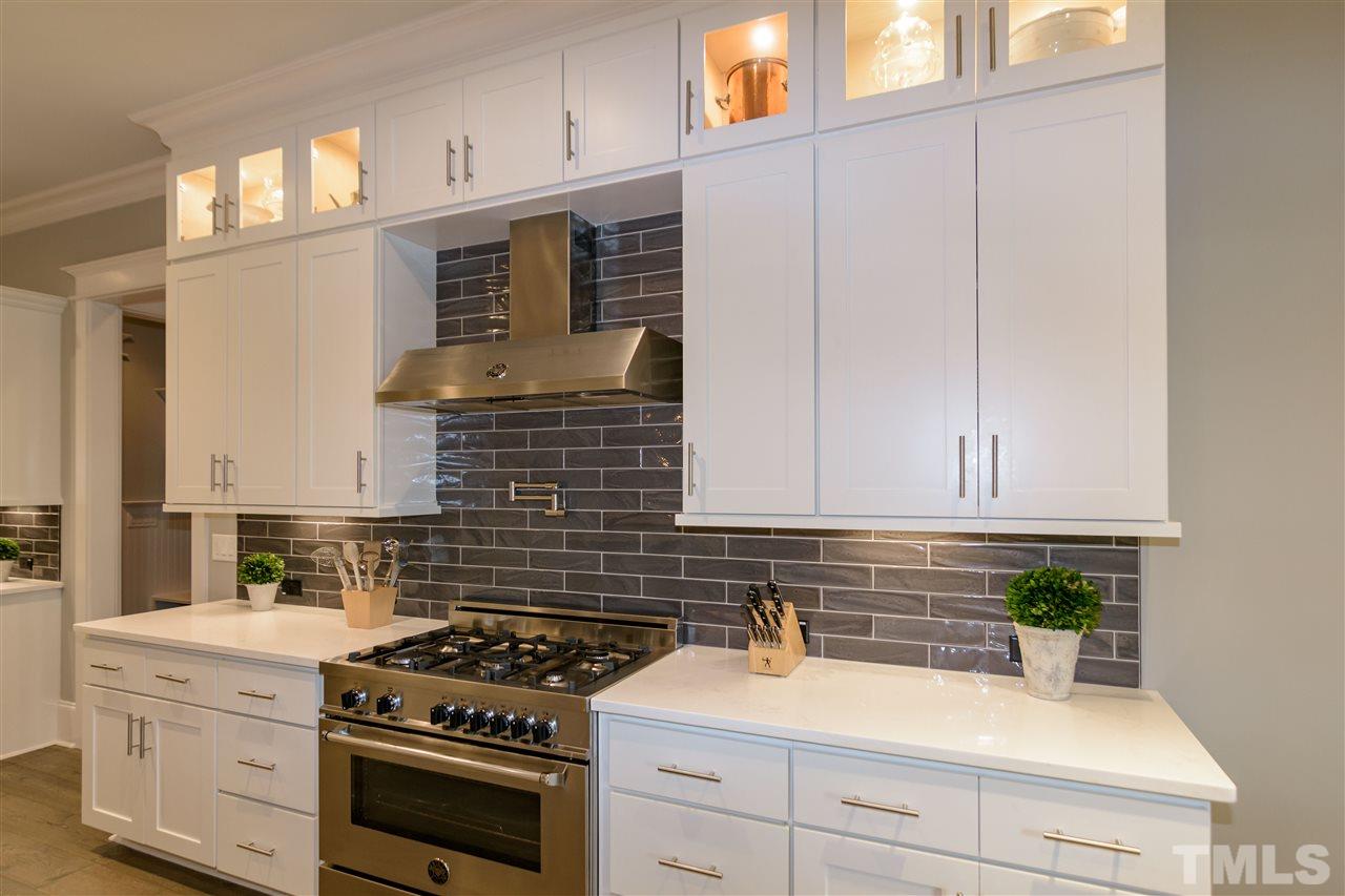 1216 Hunting Ridge Road Raleigh, NC 27615 - Photo 11 of 30 a kitchen with stainless steel appliances white cabinets and a stove top oven