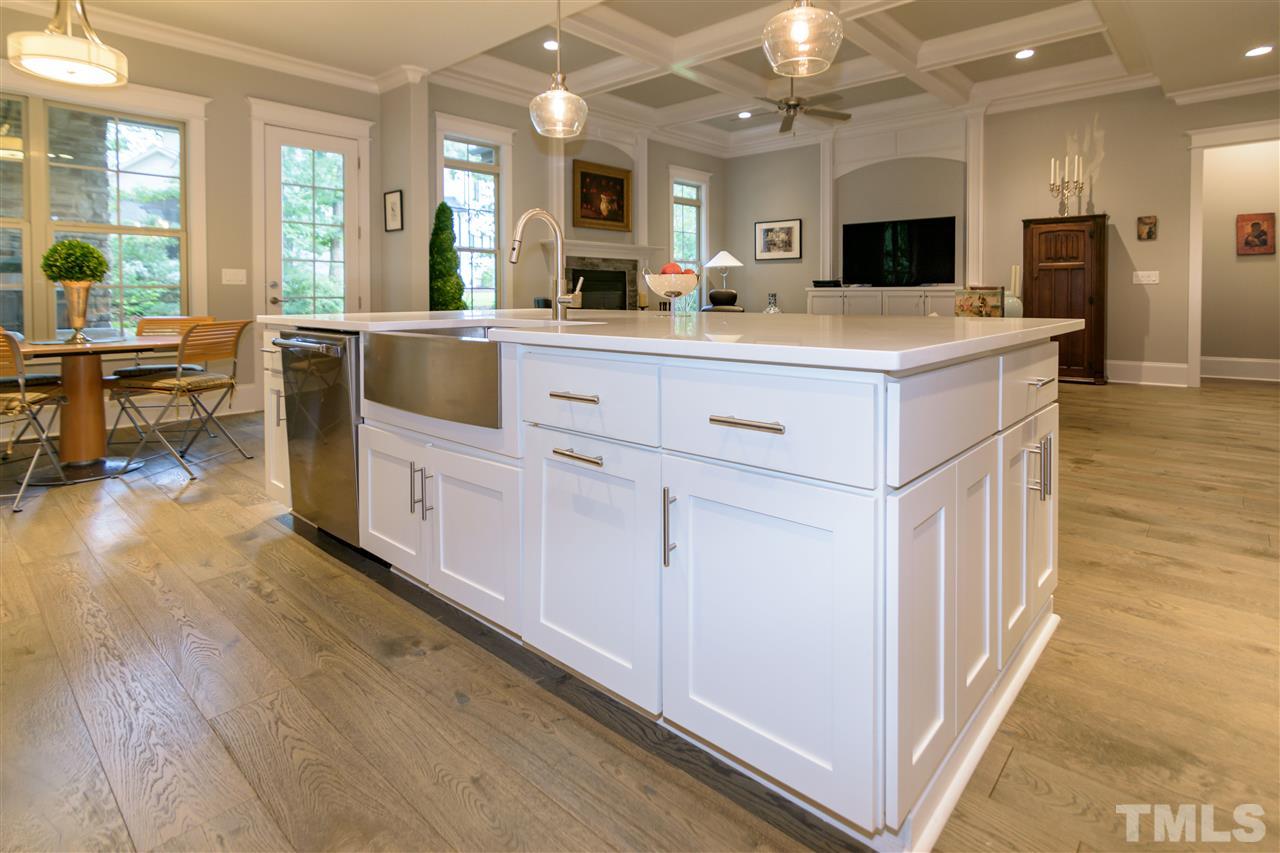 1216 Hunting Ridge Road Raleigh, NC 27615 - Photo 12 of 30 a large kitchen with kitchen island a sink a stove a dining table and chairs