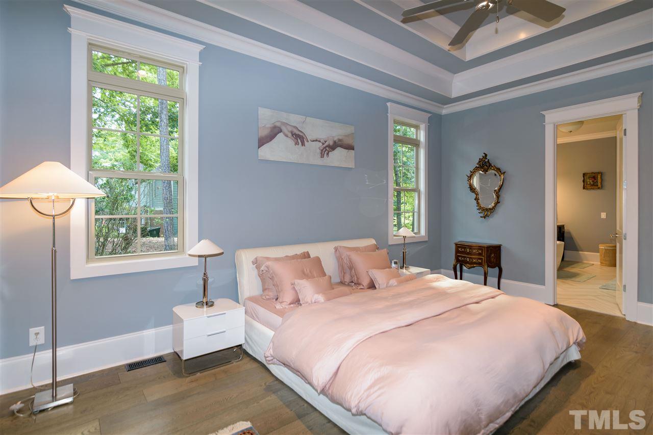 1216 Hunting Ridge Road Raleigh, NC 27615 - Photo 15 of 30 a bedroom with a bed and a chandelier
