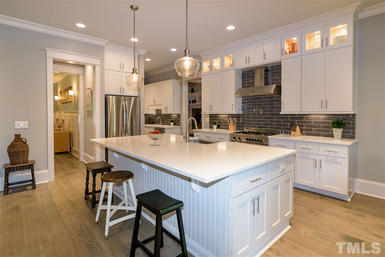 1216 Hunting Ridge Road Raleigh, NC 27615 - Photo 10 of 30 a kitchen with kitchen island a sink a stove a center island and a cabinets