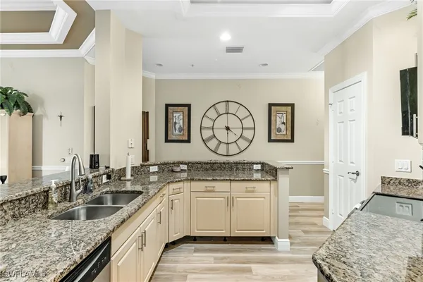 a view of a kitchen with a sink and dishwasher with wooden floor