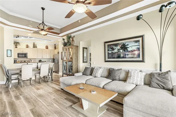 a living room with furniture a chandelier and a floor to ceiling window