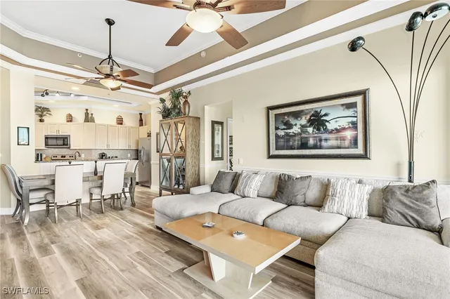a living room with furniture a chandelier and a floor to ceiling window