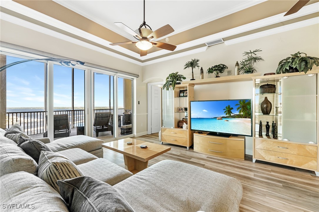 2745 First Street, Unit 2703 Fort Myers, FL 33916 - Photo 22 of 34 a living room with furniture a chandelier and a floor to ceiling window