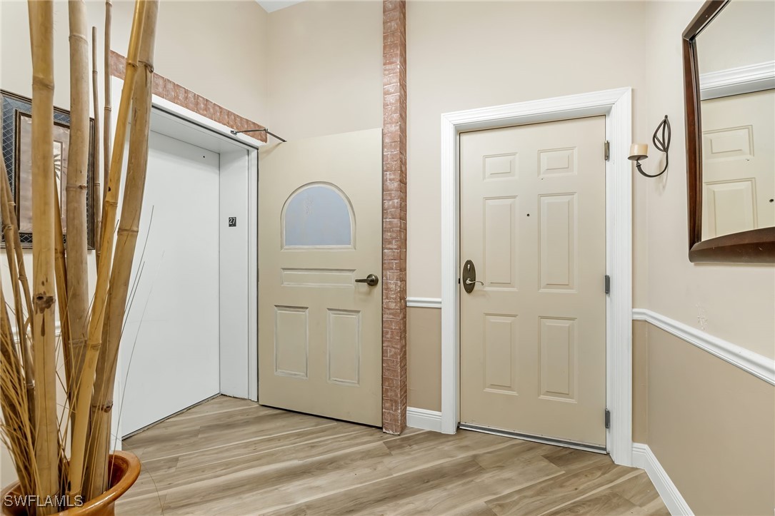 2745 First Street, Unit 2703 Fort Myers, FL 33916 - Photo 3 of 34 an empty room with wooden floor and a window