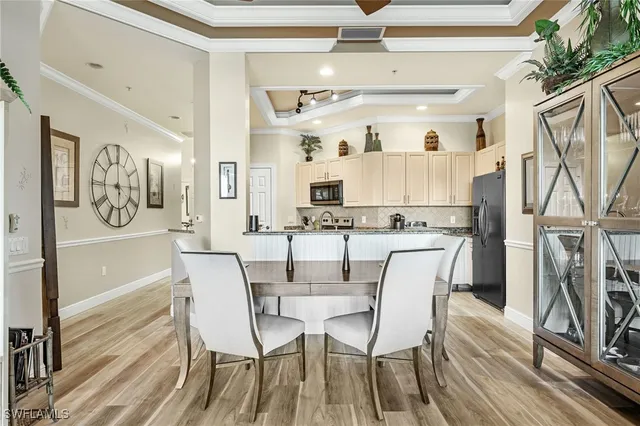 a view of a dining room with furniture a kitchen and chandelier