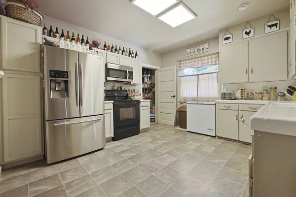 a kitchen with stainless steel appliances a refrigerator sink and cabinets