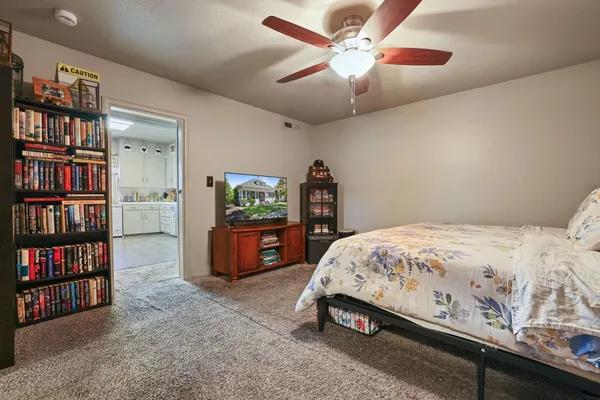 a bedroom with a bed a book shelf and a shelf
