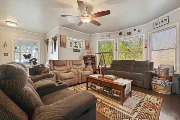 a living room with furniture a large window and a chandelier