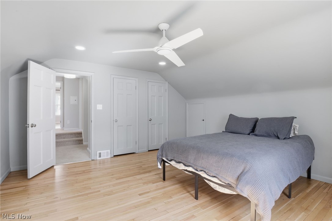 1390 Brainard Road Lyndhurst, OH 44124 - Photo 18 of 33 Bedroom with two closets, vaulted ceiling, light wood-style flooring, and a ceiling fan