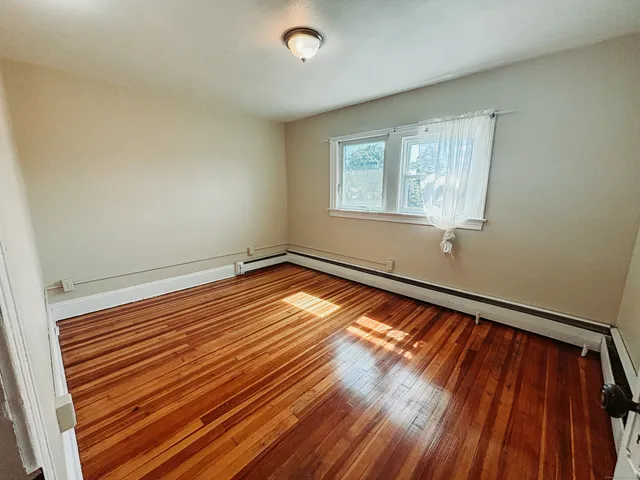 a view of a room with wooden floor and window