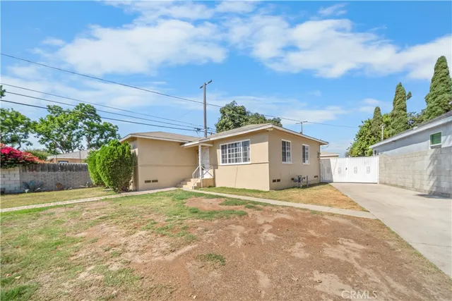 a view of a house with a yard and potted plants