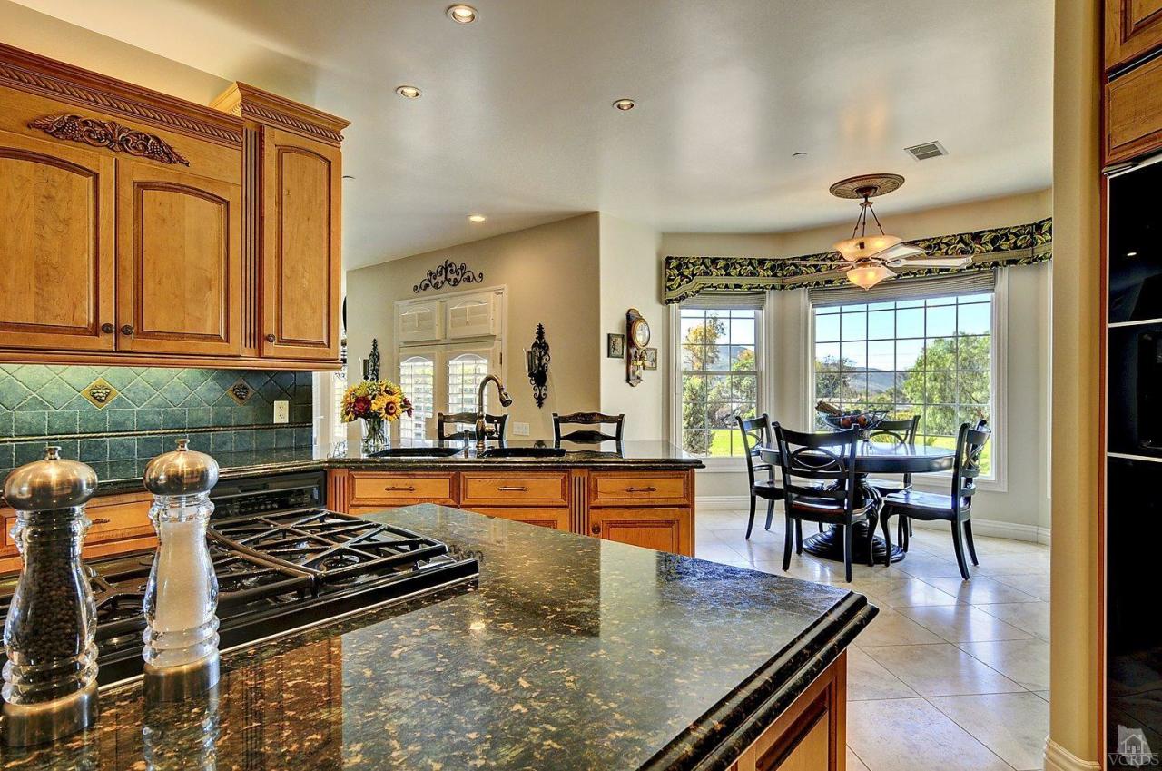 2371 Duval Road Camarillo, CA 93012 - Photo 8 of 50 a kitchen with stainless steel appliances granite countertop a stove top oven a dining table and chairs with wooden floor