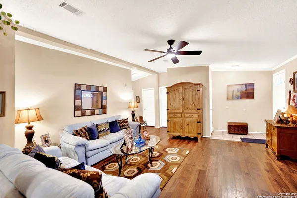 a living room with furniture stairs and a wooden floor