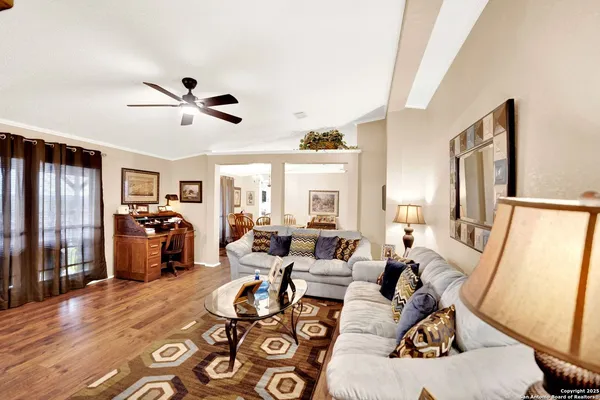 a living room with furniture two window and a flat screen tv