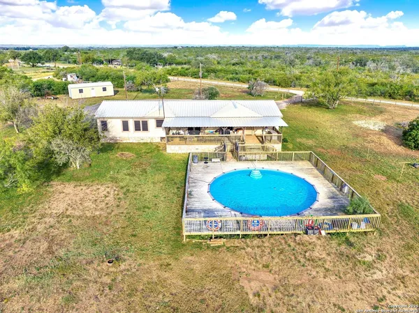 an aerial view of residential houses with outdoor space and swimming pool