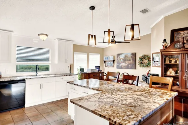 a large kitchen with kitchen island a large counter space and stainless steel appliances