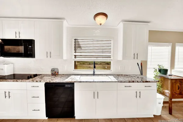 a kitchen with granite countertop a sink window and a counter space