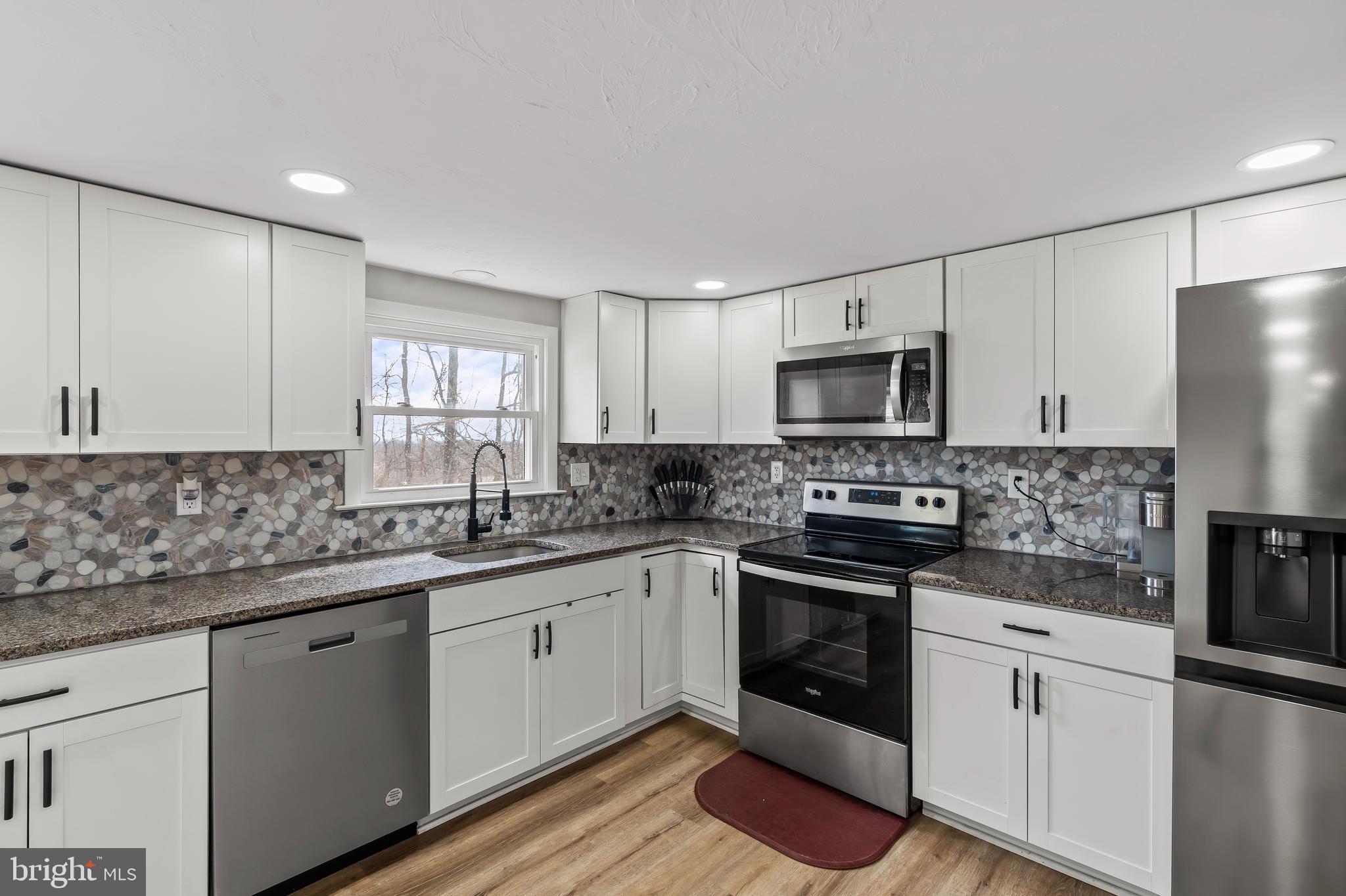 5150 Nursery Road Dover, PA 17315 - Photo 8 of 38 a kitchen with granite countertop white cabinets and stainless steel appliances