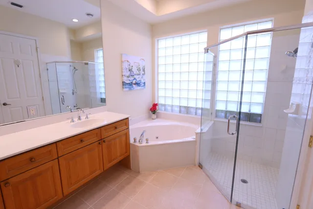 a bathroom with a tub sink shower and mirror