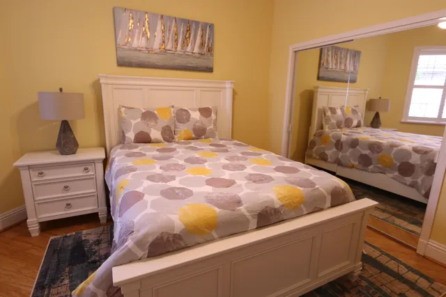 a bedroom with a bed and wooden floor